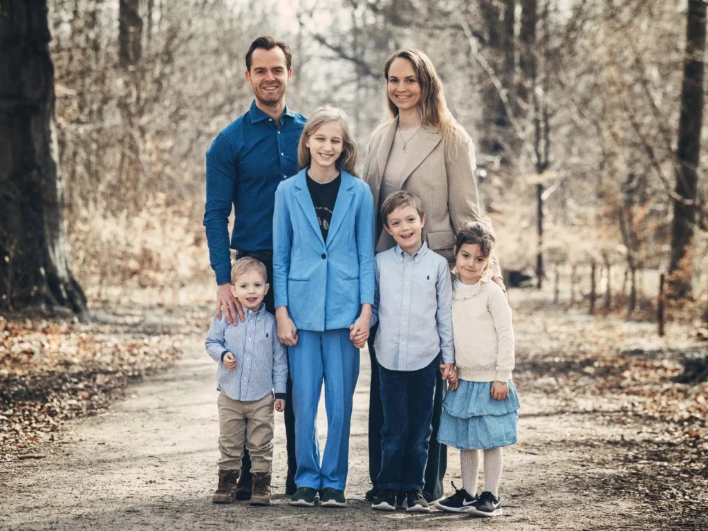 Family with four children standing together in the woods