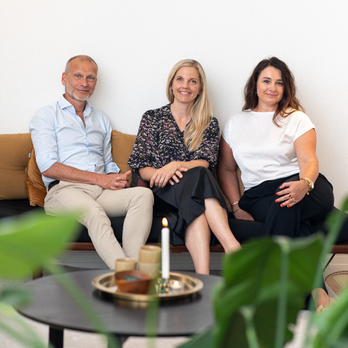 Three staff members sitting together for a group portrait