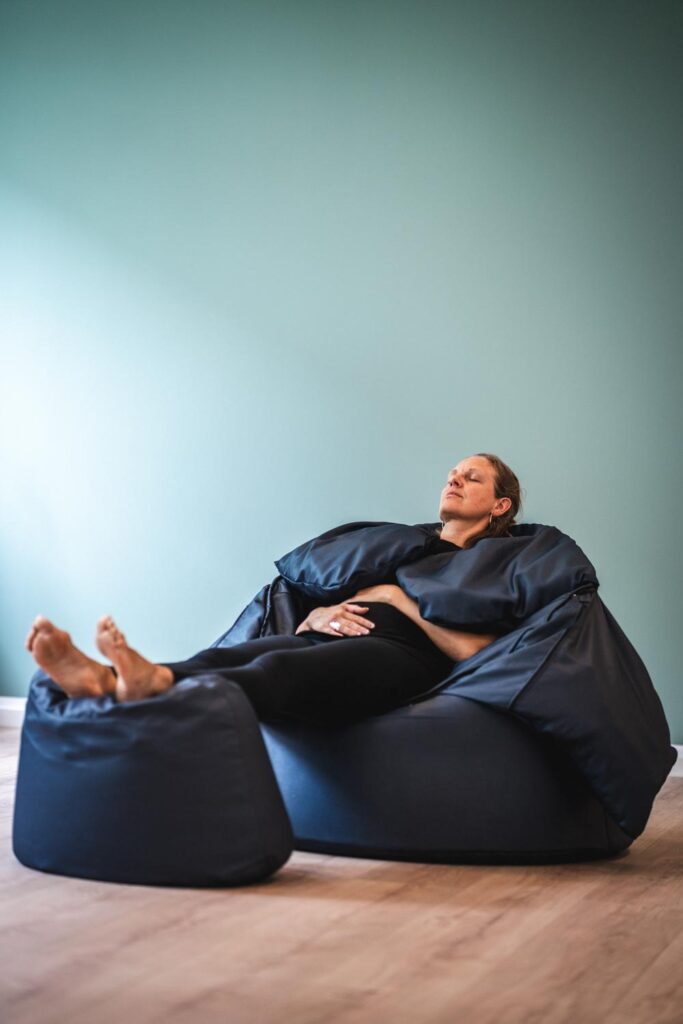 A man photographed sitting on a blue sofa