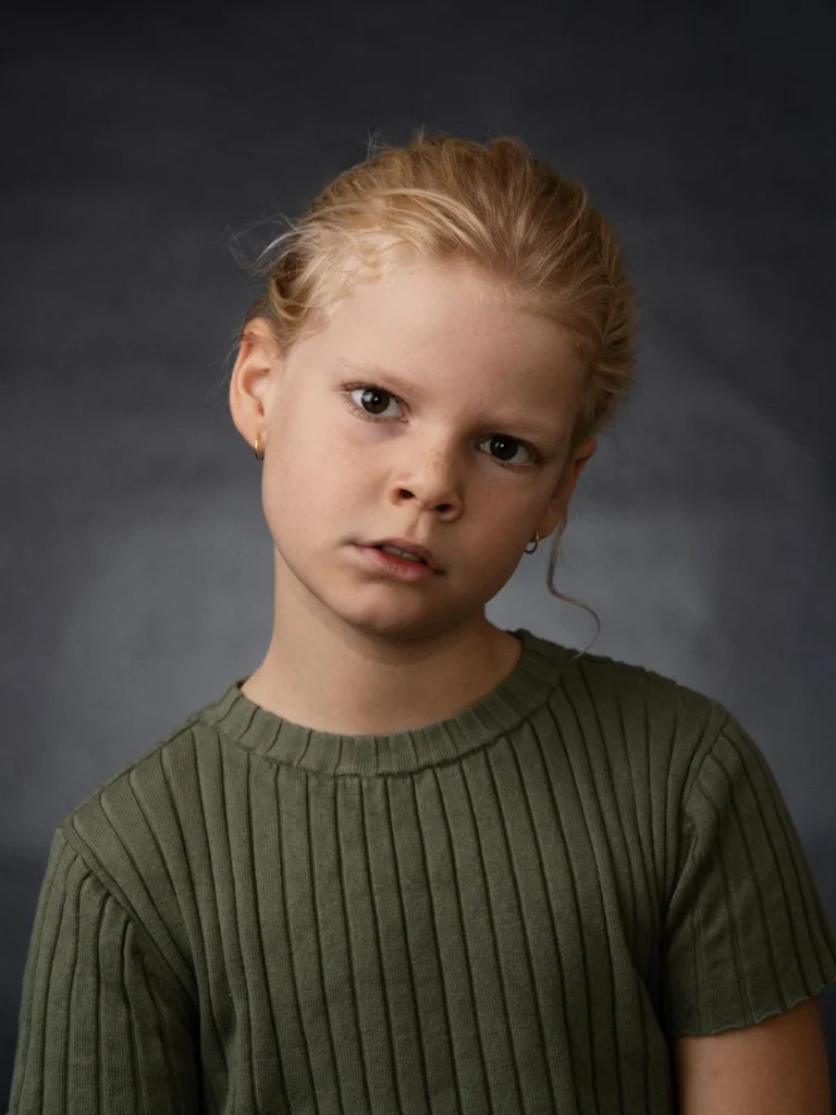 Child portrait with tied-back hair and a green top Child portrait with tied-back hair and a green top