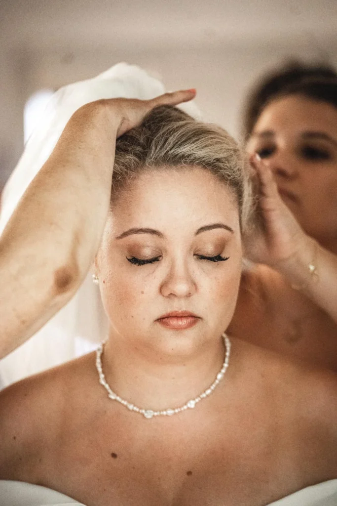 Bride having her hair styled before the wedding