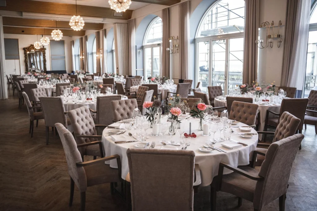Celebration venue with round set tables and large windows Celebration venue with round set tables and large windows