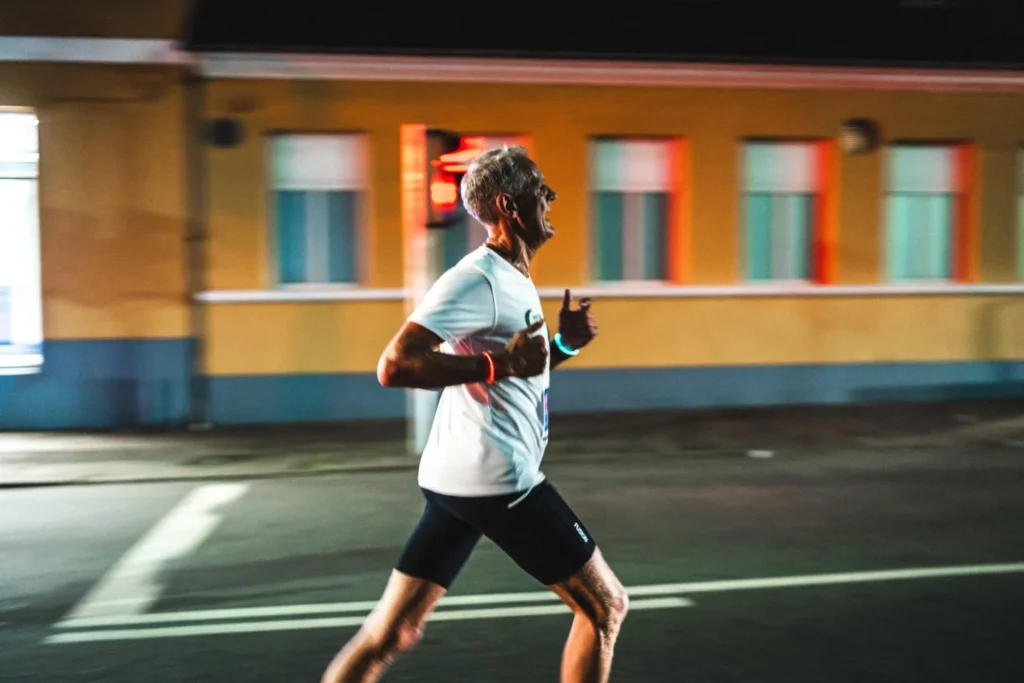 Runner on a city street with a colourful building behind Runner on a city street with a colourful building behind