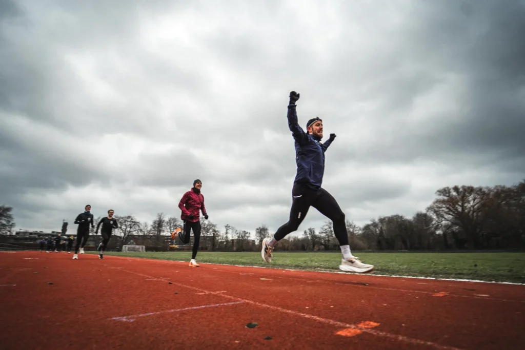 Runner jumping on a track under an overcast sky Runner jumping on a track under an overcast sky