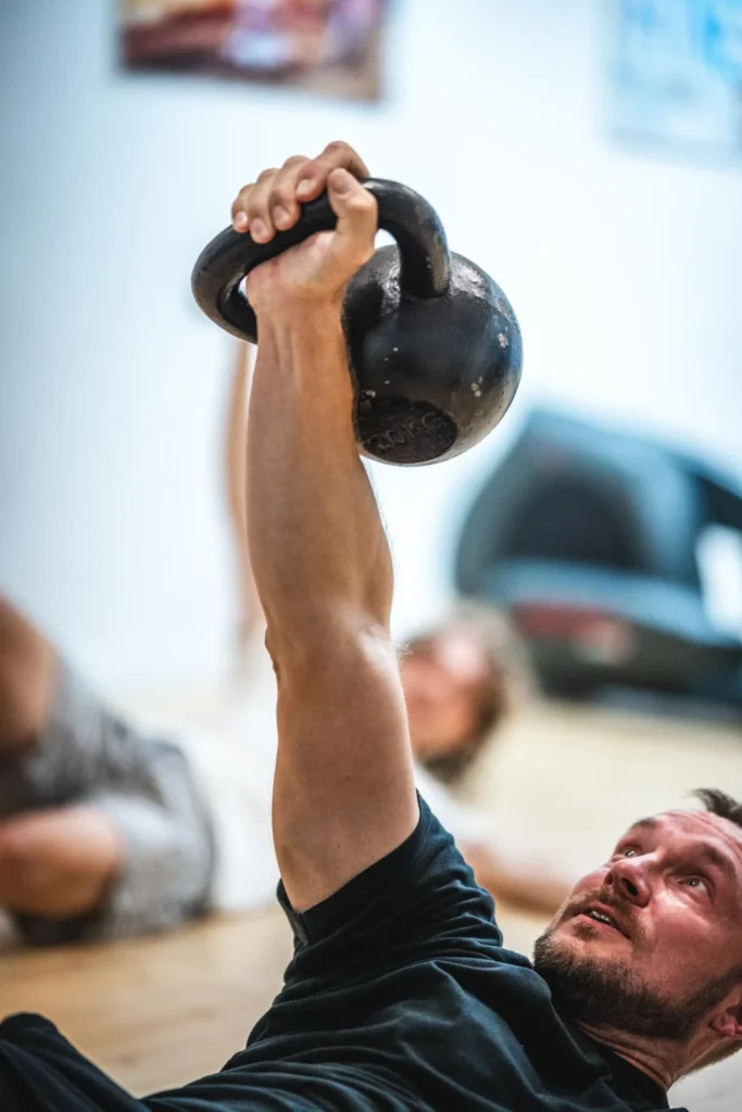 Person holding a kettlebell above their chest during a workout Person holding a kettlebell above their chest during a workout