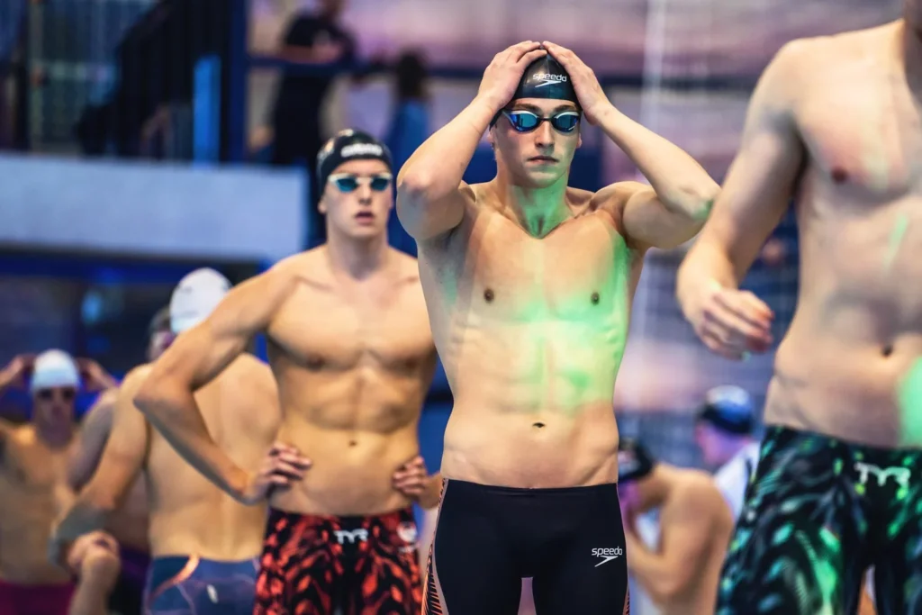 Swimmers wearing goggles preparing beside the pool Swimmers wearing goggles preparing beside the pool